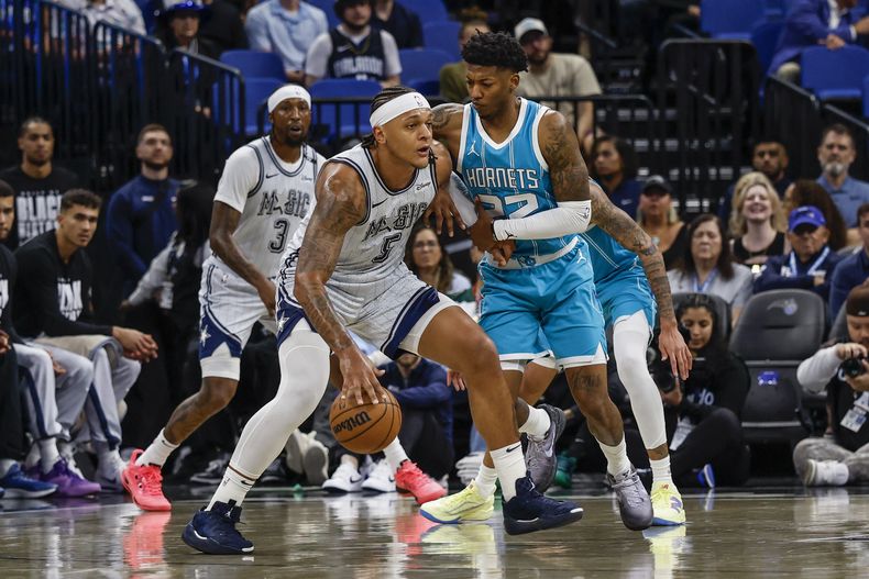 Paolo Banchero (5), del Magic de Orlando, es defendido por Elfrid Payton, de los Hornets de Charlotte, durante la primera mitad del juego de baloncesto de la NBA, el miércoles 12 de febrero de 2025, en Orlando, Florida. (AP Foto/Kevin Kolczynski)