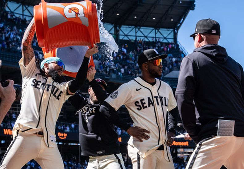 J.P. Crawford baña a su compañero de los Marineros de Seattle Victor Robles tras la victoria ante los Diamondbacks de Arizona el domingo 31 de mayo del 2026. (AP Foto/Stephen Brashear)