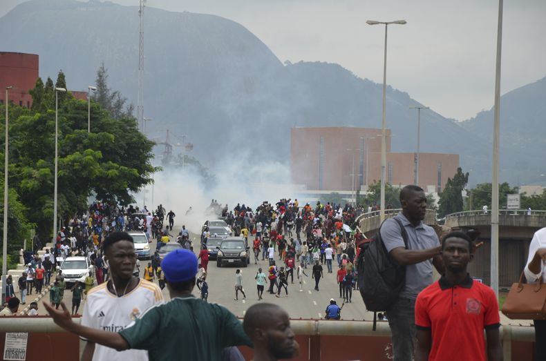 Agentes de policía disparan gases lacrimógenos durante una protesta en Abuya, Nigeria, el 1 de agosto de 2024. (AP Foto/Olamikan Gbemiga )