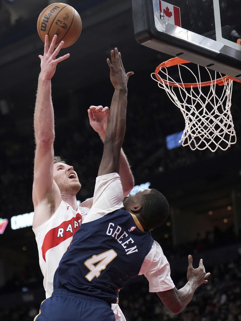 Jakob Poeltl de los Raptors de Toronto dispara al aro sobre Javonte Green de los Pelicans de Nueva Orleans, el lunes 27 de enero de 2025. (Nathan Denette/The Canadian Press vía AP)