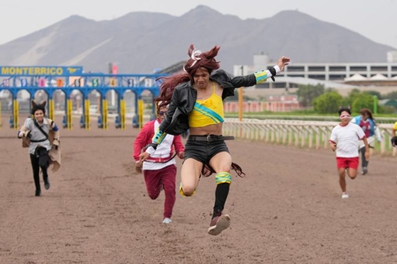Piero Lavalle, vestido como un caballo de carreras inspirado en la franquicia japonesa Umamusume: Pretty Derby cruza la meta en el hipódromo de Monterrico en Lima, Perú, el viernes 27 de febrero de 2026. (Foto AP/Martín Mejía)