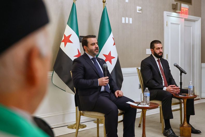 En esta imagen difundida por la Oficina de Prensa de la Presidencia de Siria, el presidente sirio Ahmad al-Sharaa, a la derecha, acompañado del ministro del Exterior de Siria, Asaad al-Shibani, durante una reunión con representantes de organizaciones sirias estadounidenses, el sábado 8 de noviembre de 2025, en Washington. (Oficina de Prensa de la Presidencia de Siria vía AP)