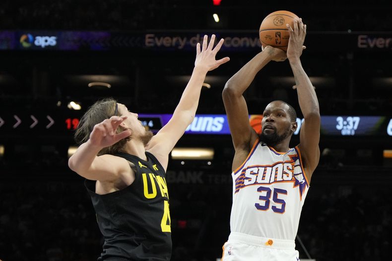 Kevin Durant, alero de los Suns de Phoenix, dispara frente a Kelly Olynyk, del Jazz de Utah, el sábado 28 de octubre de 2023 (AP Foto/Rick Scuteri)