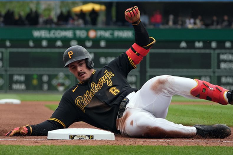 Konnor Griffin, de los Piratas de Pittsburgh, se desliza hacia la tercera base tras su triple ante el lanzador de los Rojos de Cincinnati, Brock Burke, en la cuarta entrada de un partido de béisbol en Pittsburgh, el sábado 2 de mayo de 2026. (AP Foto/Tom E. Puskar)