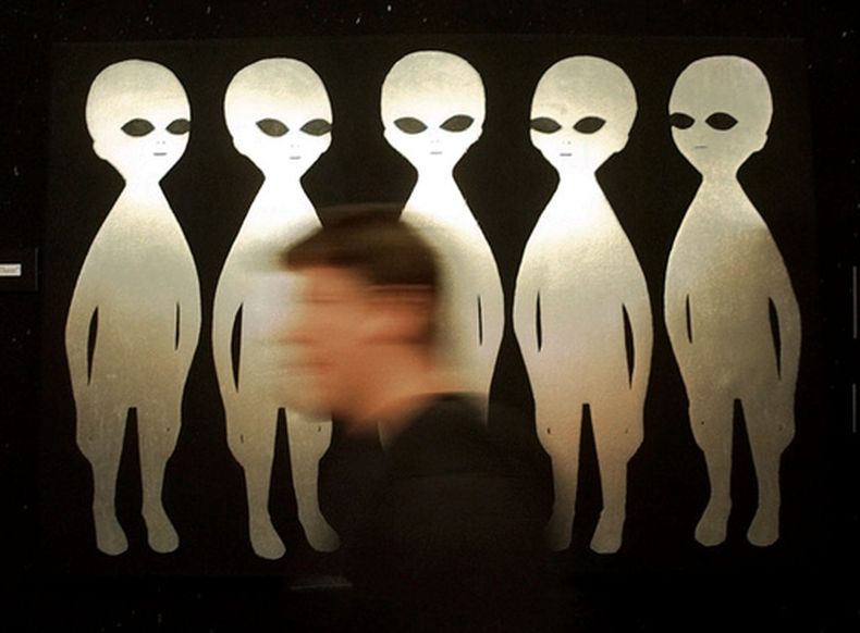 Una persona camina frente a una pintura en el Museo Internacional y Centro de Investigación Ovni, el 10 de junio de 1997, en Roswell, Nuevo México. (AP Foto/Eric Draper, Archivo)