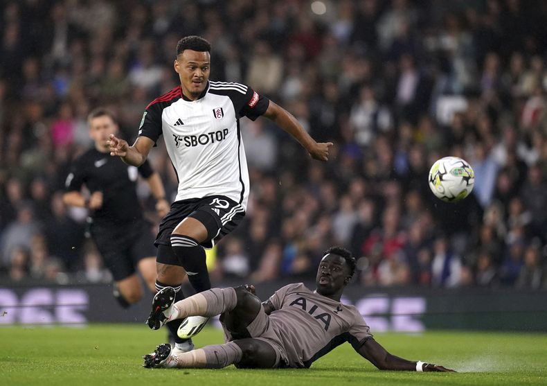 El defensa colombiano Davinson Sánchez del Tottenham Hotspur disputa el balón ante Rodrigo Muniz del Fulham (izquierda), durante el partido de la 2da ronda de la Copa de la Liga en Craven Cottage, Londres. Martes 29 de agosto de 2023. (John Walton/PA via AP)