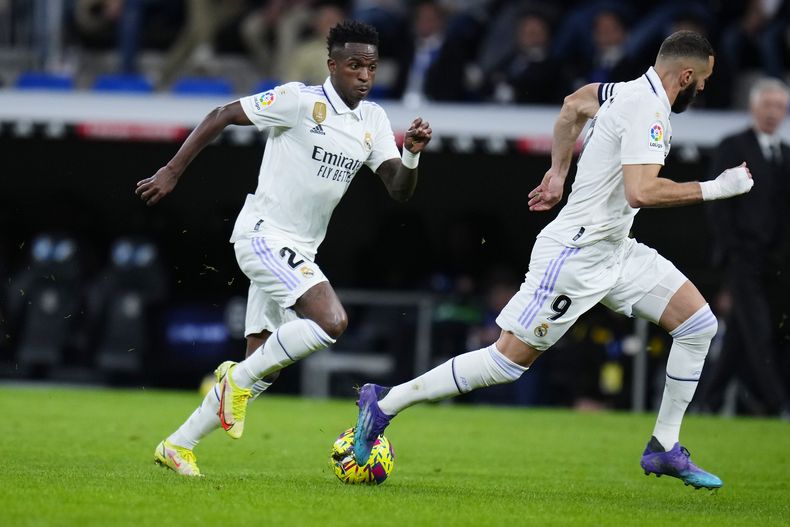 Vinicius Junior del Real Madrid y Karim Benzema controlan el balón durante el encuentro de la liga española ante el Celta de Vigo el sábado 22 de abril del 2023. (AP Foto/Manu Fernandez)