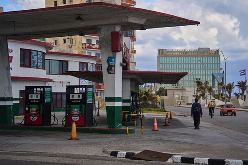 Un hombre pasa junto a una gasolinera sin combustible, ubicada cerca de la embajada de Estados Unidos (al fondo), el sábado 7 de febrero de 2026, en La Habana, Cuba. (AP Foto/Ramón Espinosa)
