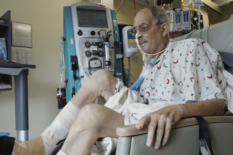 En esta imagen de un video proporcionado por la Facultad de Medicina de la Universidad de Maryland, Lawrence Faucette, paciente de un trasplante de corazón de cerdo, trabaja con un fisioterapeuta en el hospital de la facultad en Baltimore, Maryland, el miércoles 18 de octubre de 2023. (Tom Jemski/University of Maryland School of Medicine via AP)