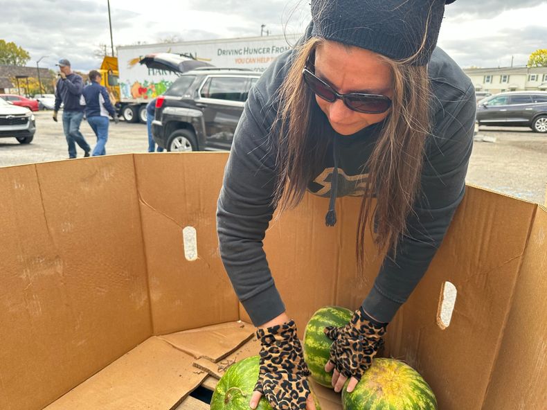 Una voluntaria organiza sandías en un contenedor durante un evento de distribución de alimentos de Forgotten Harvest celebrado en la Iglesia Bíblica Woodside, el viernes 24 de octubre de 2025, en Pontiac, Michigan. (AP Foto/Mike Householder)