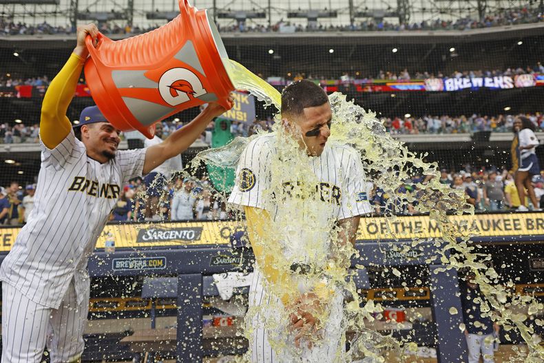 Willy Adames (izquierda) de los Cerveceros de Milwaukee baña con Gatorade a Joey Ortiz tras la victoria ante los Rojos de Cincinnati, el sábado 15 de junio de 2024, en Milwaukee. (AP Foto/Jeffrey Phelps)
