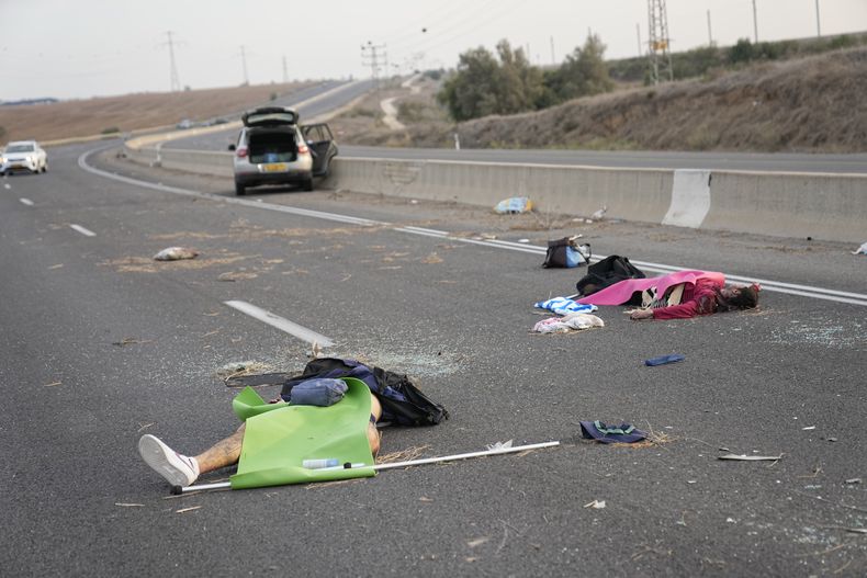 Israelíes asesinados por insurgentes de Hamás, tendidos sobre el asfalto en una carretera cerca de Sderot, Israel, el 7 de octubre de 2023. Insurgentes de Hamás en la Franja de Gaza se infiltraron en el sur de Israel y dispararon miles de proyectiles al país mientras Israel comenzaba a atacar objetivos en el enclave palestino en respuesta. (AP Foto/Ohad Zwigenberg)