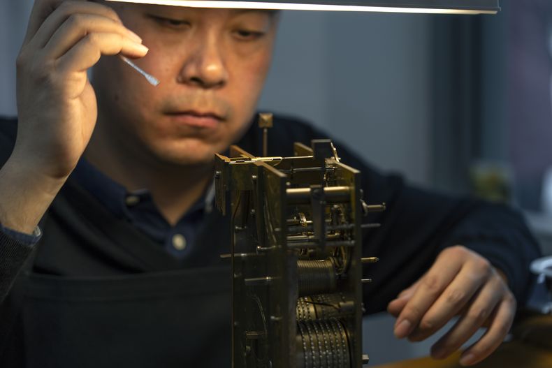 Un restaurador trabaja en el mecanismo de un reloj antiguo en un taller dentro de la Ciudad Prohibida, también conocida como Museo del Palacio Imperial, el viernes 21 de febrero de 2025, en Beijing. (AP Foto/Ng Han Guan)