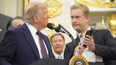 El reportero de Fox News Peter Doocy le muestra al presidente Donald Trump una fotografía en su teléfono durante un evento en el Despacho Oval de la Casa Blanca sobre la reubicación de la sede del Comando Espacial de Estados Unidos, el martes 2 de septiembre de 2025, en Washington. (AP Foto/Mark Schiefelbein)