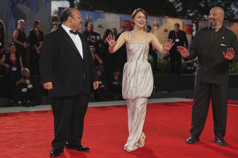 Stavros Halkias, de izquierda a derecha, Emma Stone, y el director Yorgos Lanthimos posan en la alfombra roja de la película Bugonia durante la 82a edición del Festival de Cine de Venecia en Venecia, Italia, el jueves 28 de agosto de 2025. (Foto Scott A Garfitt/Invision/AP)