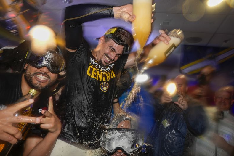 El dominicano Willy Adames, de los Cerveceros de Milwaukee, derrama champaña en el festejo tras la victoria sobre los Filis de Filadelfia, el miércoles 18 de septiembre de 2024 (AP Foto/Morry Gash)