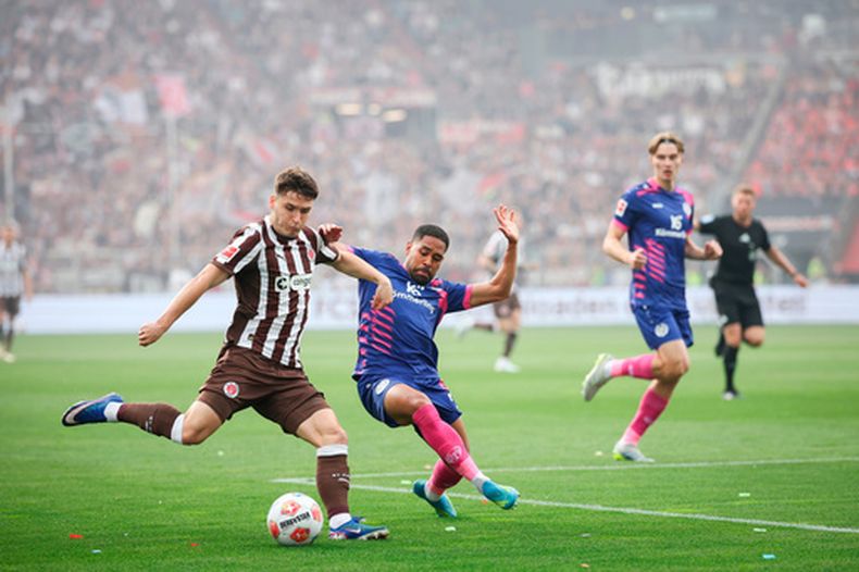 Arkadiusz Pyrka del St. Pauli y Phillipp Mwene del Mainz pelean por el balón en el encuentro de la Bundesliga el domingo 3 de mayo del 2026. (Christian Charisius/dpa via AP)