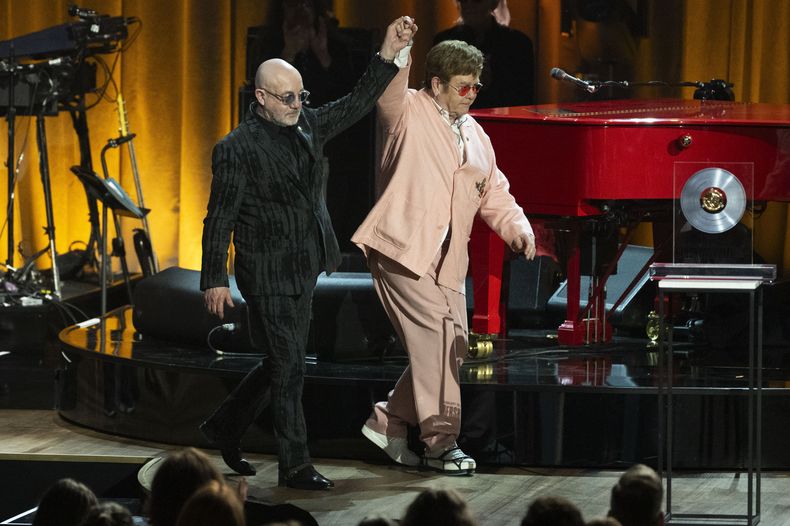 Elton John, izquierda, camina con Bernie Taupin en la ceremonia del Premio Gershwin a la Canción Popular de la Biblioteca del Congreso 2024 en honor a John y Taupin en el DAR Constitution Hall el miércoles 20 de marzo de 2024, en Washington. (Foto AP/Kevin Wolf)