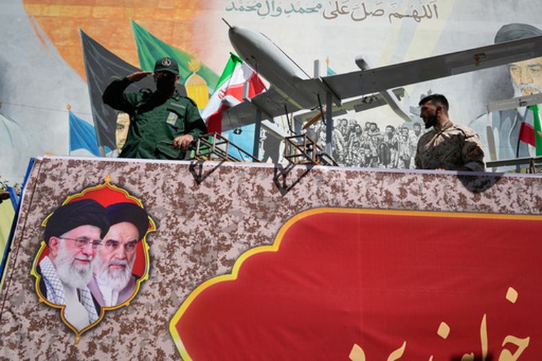 Un miembro de la Guardia Revolucionaria de Irán saluda a bordo de una carroza para exhibir drones durante el Janfada (Sacrificio por Irán), un desfile de estilo militar organizado por el Estado, en Teherán, Irán, el 18 de septiembre de 2026. (AP Foto/Vahid Salemi)