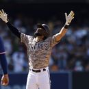 Fernando Tatis Jr., derecha, de los Padres de San Diego, alza los brazos después de conectar un sencillo productor de una carrera frente a los Rangers de Texas en la novena entrada del juego de béisbol, el domingo 30 de julio de 2023, en San Diego. (AP Foto/Derrick Tuskan)