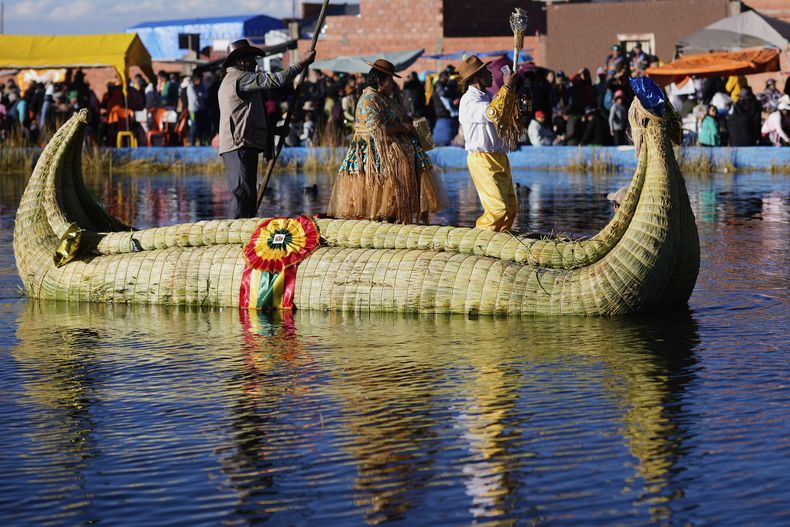 Bailarines en una balsa mientras atraviesan una laguna interior para La Morenada durante las celebraciones al apóstol Santiago, en Guaqui, Bolivia, el viernes 25 de julio de 2025. (AP Foto/Juan Karita)