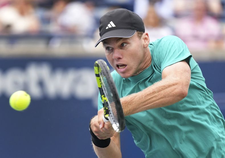 Alex Michelsen, de Estados Unidos, devuelve la pelota contra Lorenzo Musetti, de Italia, durante un partido en el torneo de tenis masculino National Bank Open, el jueves 31 de julio de 2025, en Toronto. (Nathan Denette/The Canadian Press vía AP)