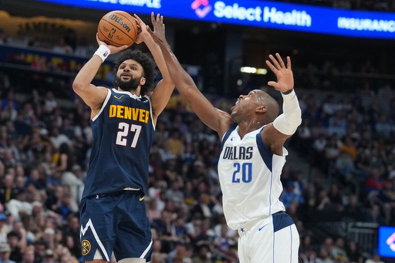 Jamal Murray, izquierda, de los Nuggets de Denver, se alza para disparar sobre Khris Middleton (20) de los Mavericks de Dallas, defiende en la segunda mitad del juego de baloncesto de la NBA, el miércoles 25 de marzo de 2026, en Denver. (AP Foto/David Zalubowski)