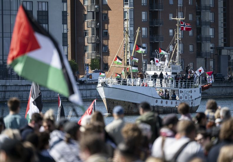ARCHIVO - Manifestantes con banderas palestinas miran mientras el barco con destino a Gaza Handala llega al puerto de Malmö, Suecia, el miércoles 8 de mayo de 2024.(Johan Nilsson/TT News Agency via AP, Archivo)