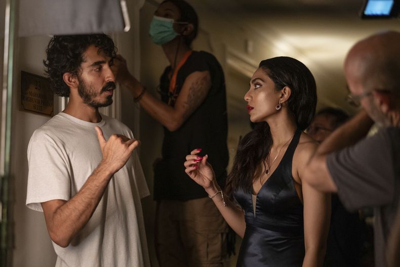 En esta imagen proporcionada por Universal Pictures, Dev Patel, izquierda, y Sobhita Dhulipala en el set de la película Monkey Man. (Universal Pictures via AP)