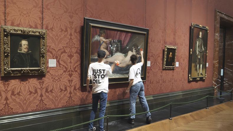 En esta fotografía proporcionada por el grupo activista ambiental Just Stop Oil el lunes 6 de noviembre de 2023, activistas golpean el vidrio protector de una pintura de Diego Velázquez en la National Portrait Gallery de Londres. (Just Stop Oil vía AP)