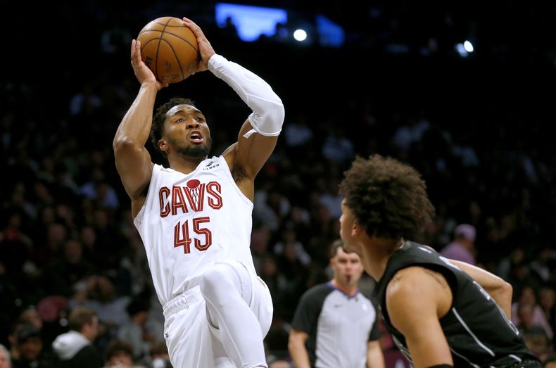 Donovan Mitchell, base de los Cavaliers de Cleveland, dispara frente a Jalen Wilson, de los Nets de Brooklyn, en el partido del jueves 8 de febrero de 2024 (AP Foto/John Munson)