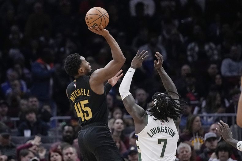 Donovan Mitchell, base de los Cavaliers de Cleveland, dispara frente a Chris Livingston, de los Bucks de Milwaukee, en el encuentro del miércoles 17 de enero de 2024 (AP Foto/Sue Ogrocki)