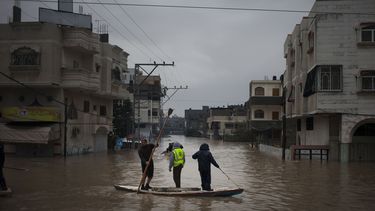 americateve | Socorristas palestinos ayudan a habitantes a evacuar una zona inundada por las fuertes lluvias en la Ciudad de Gaza, el s&aacute;bado 14 de diciembre de 2013. La Franja de Gaza recibi&oacute; su primer env&iacute;o de combustible industrial en 45 d&iacute