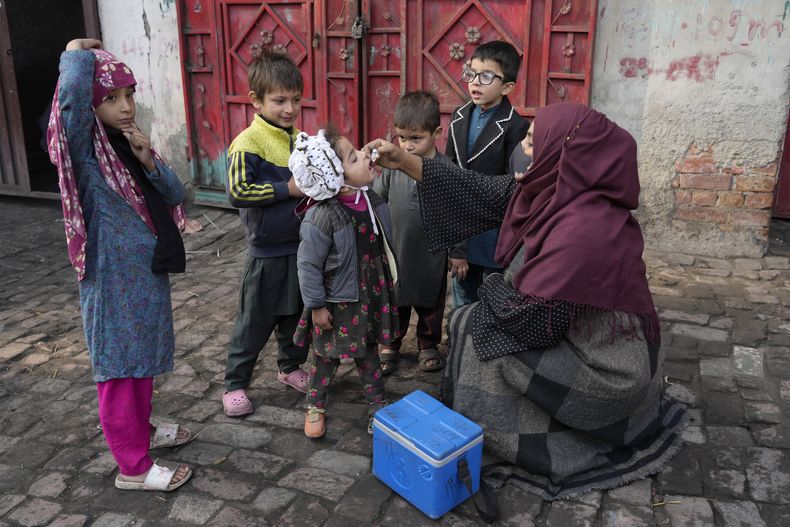 Una trabajadora de salud administra una vacuna contra la polio a una niña en una barriada de Lahore, Pakistán, el lunes 16 de diciembre de 2024. (AP Foto/K.M. Chaudary)