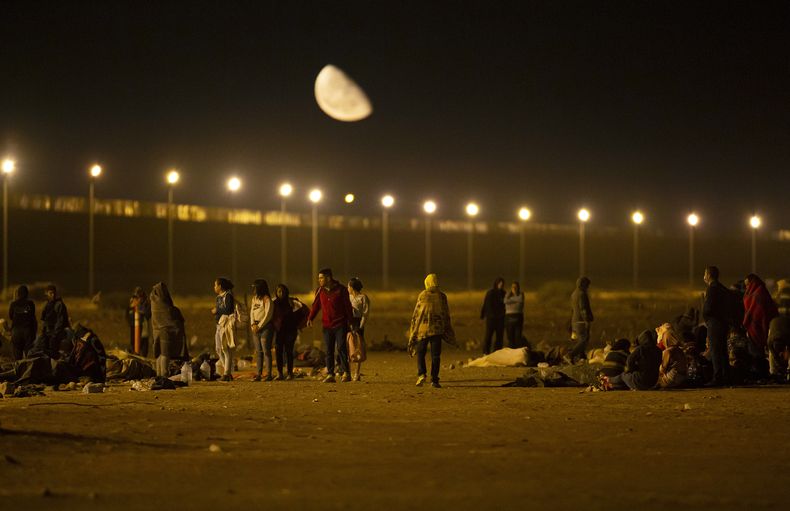 Migrantes llegan a una puerta en el muro fronterizo en la madrugada del jueves 11 de mayo de 2023, luego de cruzar desde Ciudad Juárez, México, hacia El Paso, Texas. Los migrantes se apresuraban a cruzar la frontera horas antes del fin de las restricciones al asilo relacionadas con la pandemia de COVID-19, debido al temor de que las nuevas políticas les compliquen todavía más el ingreso a Estados Unidos. (AP Foto/Andrés Leighton)