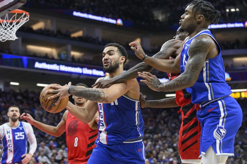 Trey Lyles, izquierda, de los Kings de Sacramento, busca la canasta durante la segunda mitad del juego de baloncesto de la NBA en contra de los Trail Blazers de Portland, el domingo 14 de abril de 2024, en Sacramento. Los Kings ganaron 121-82. (AP Foto/Randall Benton)