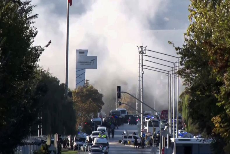 Nubes de humo se alzan en el cielo mientras equipos de rescate y agentes de la policía llegan a la compañía aeroespacial y de defensa turca TUSAS en las afueras de Ankara, Turquía, el miércoles 23 de octubre de 2024, luego de que se reportó un ataque. (IHA vía AP)
