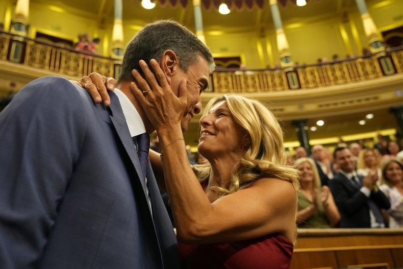 El presidente del gobierno español en funciones, Pedro Sánchez, es abrazado por la líder de Sumar, Yolanda Díaz, antes de una votación en el Congreso de los Diputados español en Madrid, España, el jueves 17 de agosto de 2023. (AP Foto/Paul White)