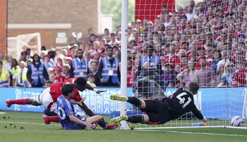 Taiwo Awoniyi, del Nottingham Forest, se estrella contra un poste, junto a Facundo Buonanott, del Leicester, en un partido de la Liga Premier, disputado el domingo 11 de mayo de 2025 (Jacob King/PA via AP)