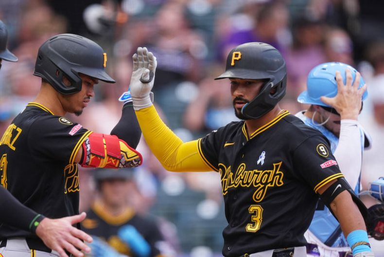 Endy Rodríguez, izquierda, de los Piratas de Pittsburgh, felicita a Nick Gonzales (3) quien cruza el plato después de batear un cuadrangular de dos carreras frente al abridor de los Rockies de Colorado, Michael Lorenzen, en la cuarta entrada del juego de béisbol de Grandes Ligas, el 21 de junio de 2026, en Denver. (AP Foto/David Zalubowski)