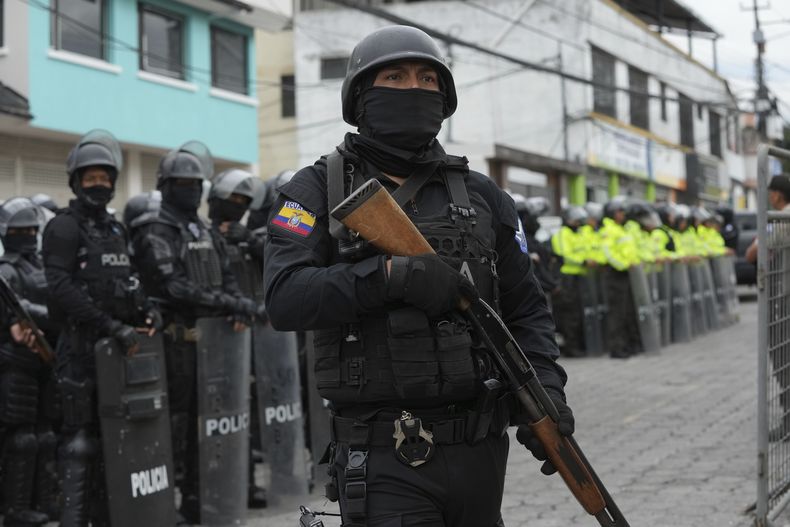 Policías y soldados se encuentran afuera de la prisión El Inca después de que comenzaron los disturbios en el interior en Quito, Ecuador, el lunes 8 de enero de 2024. El motín se produce un día después de que las autoridades ecuatorianas informaron que, en otra prisión diferente en la ciudad de Guayaquil, el líder de la pandilla Los Choneros Adolfo Macías, alias Fito, no se encontraba en su celda. Hace una década, el capo huyó de otra instalación. (Foto AP/Dolores Ochoa)