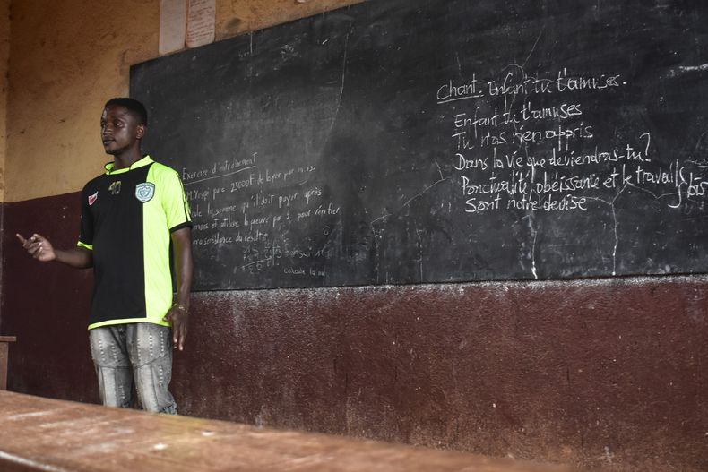 El excombatiente Ateasong Belts Tajoah imparte una clase de filosofía a sus alumnos el viernes 1 de diciembre de 2024, en Dschang, Camerún. (AP Foto/Robert Bociaga)