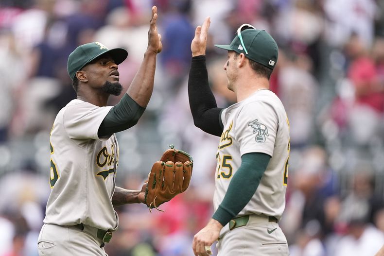 El lanzador de los Atléticos de Oakland, Dany Jiménez, celebra una victoria con el jardinero de los Atléticos de Oakland, Brent Rooker (25), contra los Bravos de Atlanta, el sábado 1 de junio de 2024, en Atlanta. (AP Foto/Brynn Anderson.