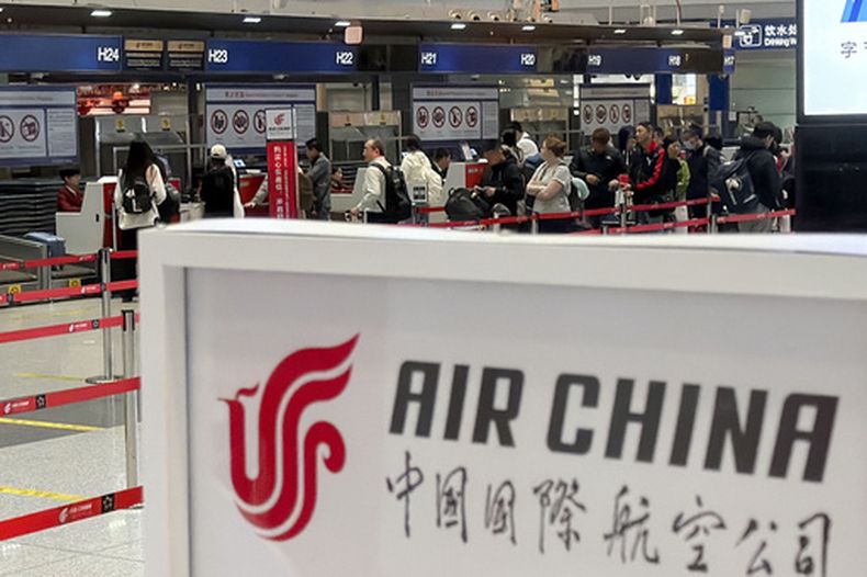 Gente hace fila ante el mostrador de Air China para toma un vuelo directo entre Beijing y la capital de Corea del Norte, Pyongyang, en el Aeropuerto Internacional Beijing Capital en Beijing, el lunes 30 de marzo de 2026. (Iori Sagisawa/Kyodo News via AP)