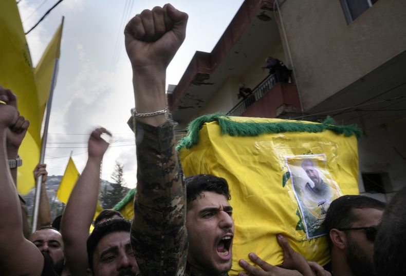 Un combatiente de Hezbollah carga el ataúd de uno de sus compañeros que murió por artillería israelí, mientras grita consignas durante una procesión fúnebre, el martes 10 de octubre de 2023, en el poblado de Khirbet Selm, en el sur de Líbano. El grupo respaldado por Irán anunció el lunes por la noche que tres de sus elementos murieron luego de un intenso bombardeo israelí contra distintos poblados en el sur de Líbano. (AP Foto/Hussein Malla)