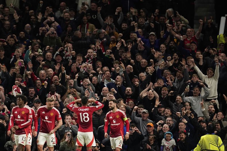 Casemiro celebra frente a los hinchas del Manchester United durante la semifinal de la Liga Europa contra el Athletic Bilbao, el jueves 8 de mayo de 2025. (AP Foto/Dave Thompson )