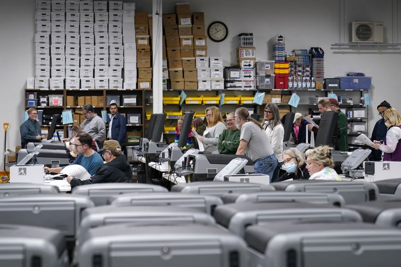 ARCHIVO - Jueces electorales muestran la precisión del equipo de votación de la ciudad el viernes 28 de octubre de 2022, en Minneapolis. Antes de cualquier elección, la ley del estado exige que las máquinas de votación de la ciudad sean probadas para medir su precisión. (AP Foto/Abbie Parr, Archivo)