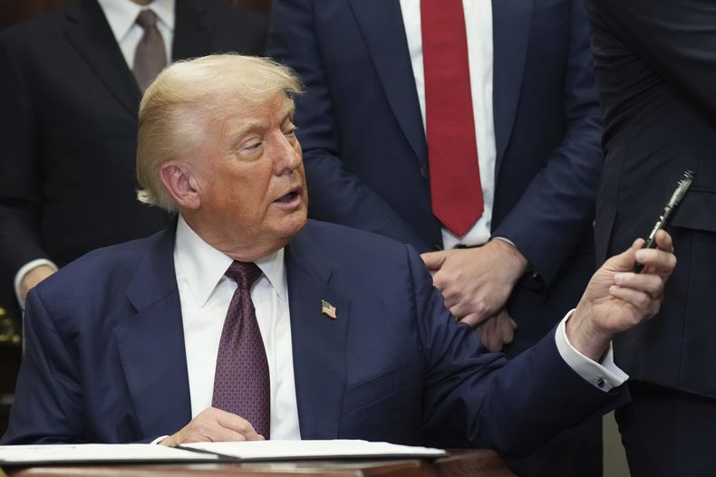 El presidente Donald Trump devuelve una pluma tras firmar una orden ejecutiva con la que se restablece la Prueba Presidencial de Aptitud Física en las escuelas públicas, el jueves 31 de julio de 2025, en el Salón Roosevelt de la Casa Blanca, en Washington. (AP Foto/Jacquelyn Martin)