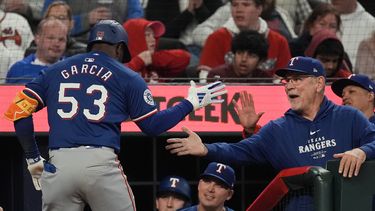 El cubano de los Rangers de Texas Adolis García (53) es felicitado por el mánager de los Rangers Bruce Bochy (derecha) en el banquillo luego de impactar un cuadrangular de dos carreras en la 8va entrada del juego ante los Bravos de Atlanta, el domingo 21 de abril de 2024, en Atlanta. (AP Foto/John Bazemore)