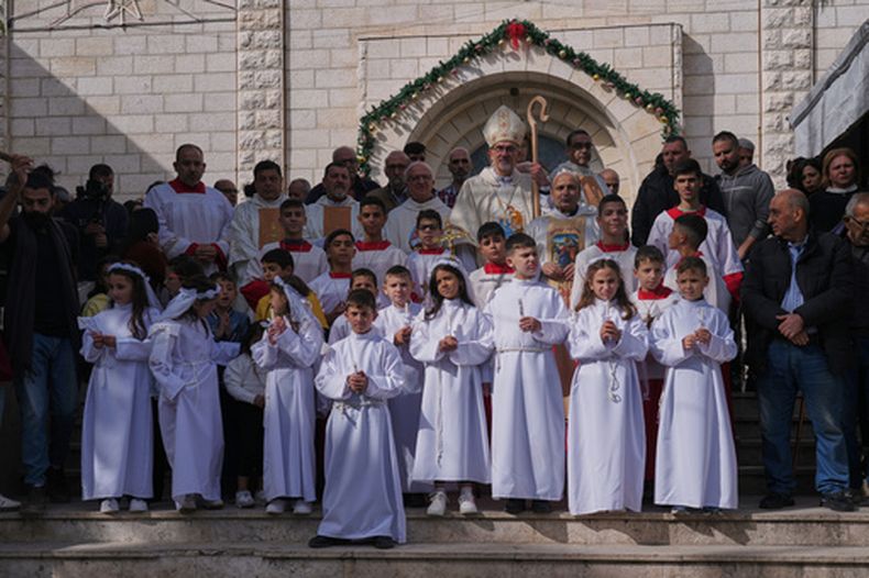 El cardenal Pierbattista Pizzaballa, el patriarca latino de Jerusalén, posa para fotos con parroquianos palestinos tras dirigir una misa antes de las celebraciones navideñas en la iglesia católica de la Sagrada Familia en Ciudad de Gaza, el domingo 21 de diciembre de 2025. (AP Foto/Jehad Alshrafi)
